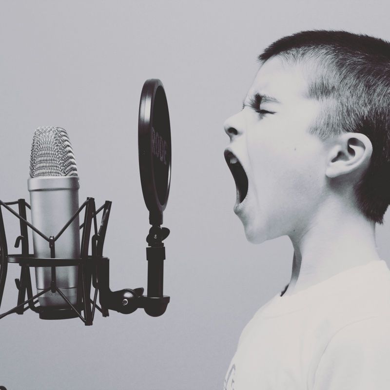 boy singing into a microphone
